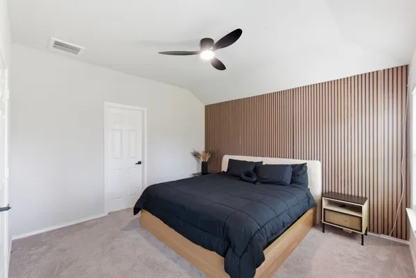 a bedroom with a bed and a ceiling fan