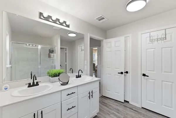 a bathroom with a double vanity sink and mirror
