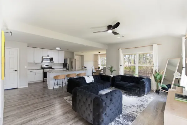 a living room with kitchen island furniture and a flat screen tv