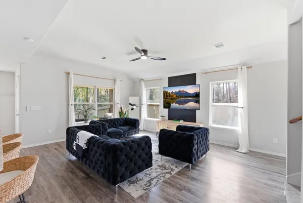 a living room with furniture a ceiling fan and a window