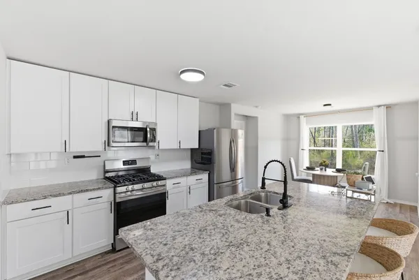 a kitchen with stainless steel appliances granite countertop a sink a stove and cabinets