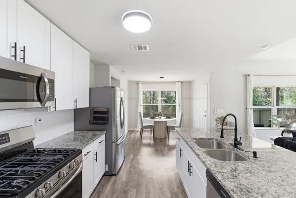 a kitchen with granite countertop a stove and a sink