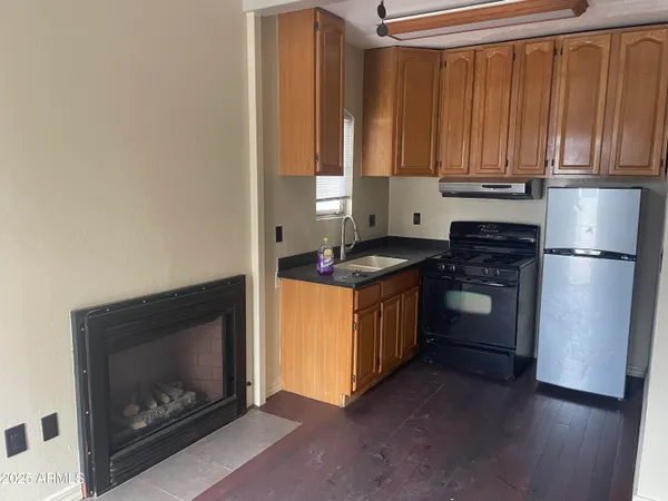 a kitchen with granite countertop wooden cabinets and a stove top oven