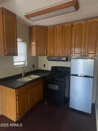a kitchen with a refrigerator stove top oven and sink