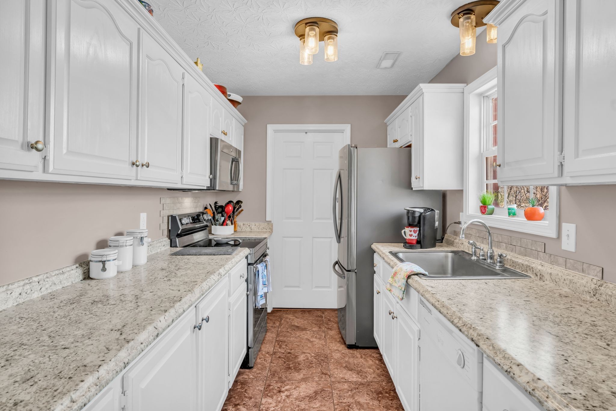 2450 Scotty Parker Road Portland, TN 37148 - Photo 13 of 37 a kitchen with stainless steel appliances granite countertop a sink stove refrigerator and cabinets