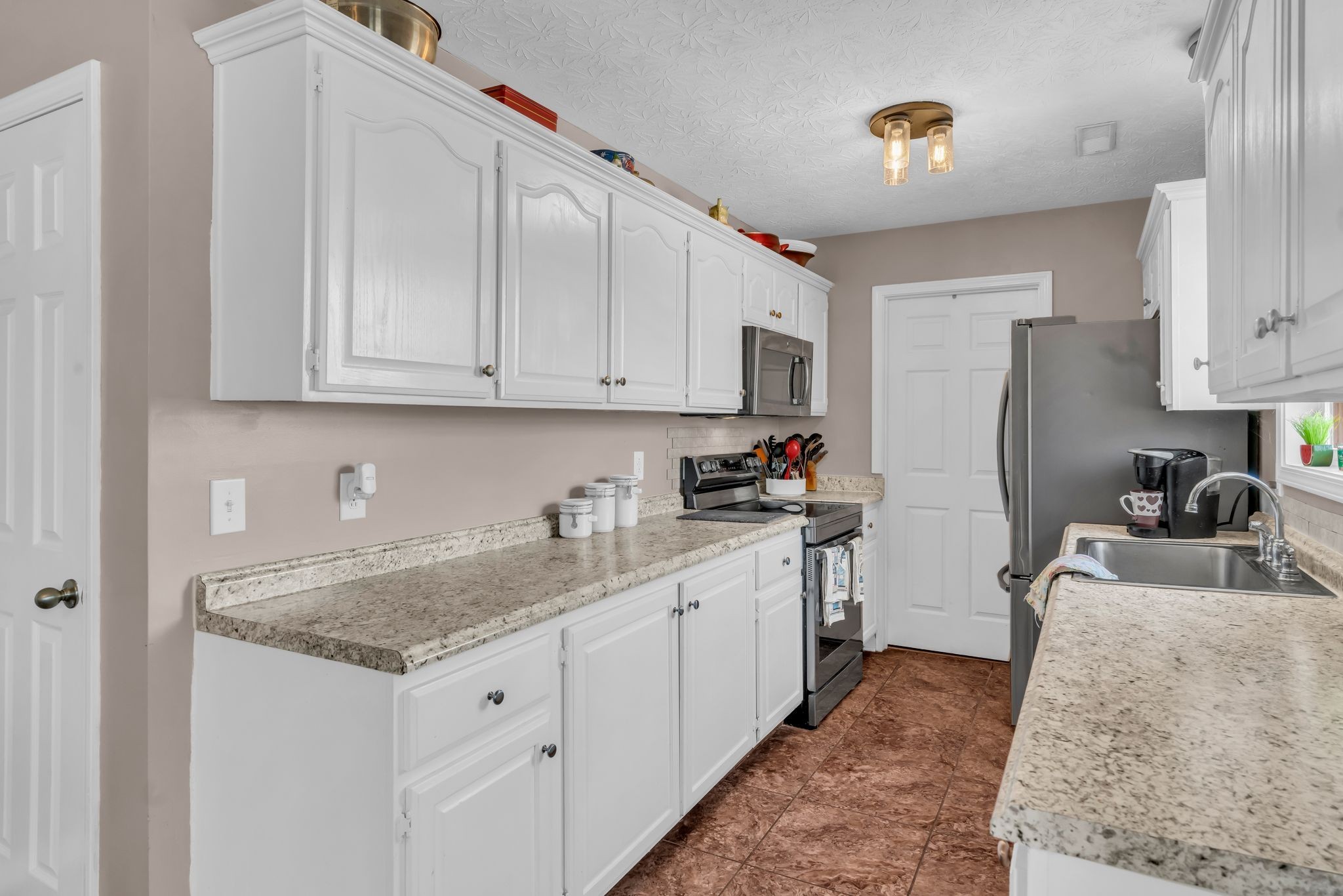 2450 Scotty Parker Road Portland, TN 37148 - Photo 14 of 37 a kitchen with stainless steel appliances granite countertop a sink stove and refrigerator