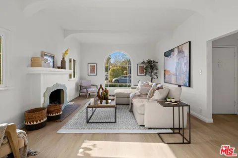 a living room with furniture a fireplace and a floor to ceiling window