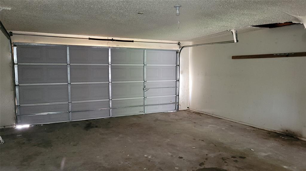 902 South Old Temple Road Hewitt, TX 76643 - Photo 26 of 32 Single-bay garage featuring a panel-style door, concrete flooring, and interior wall storage