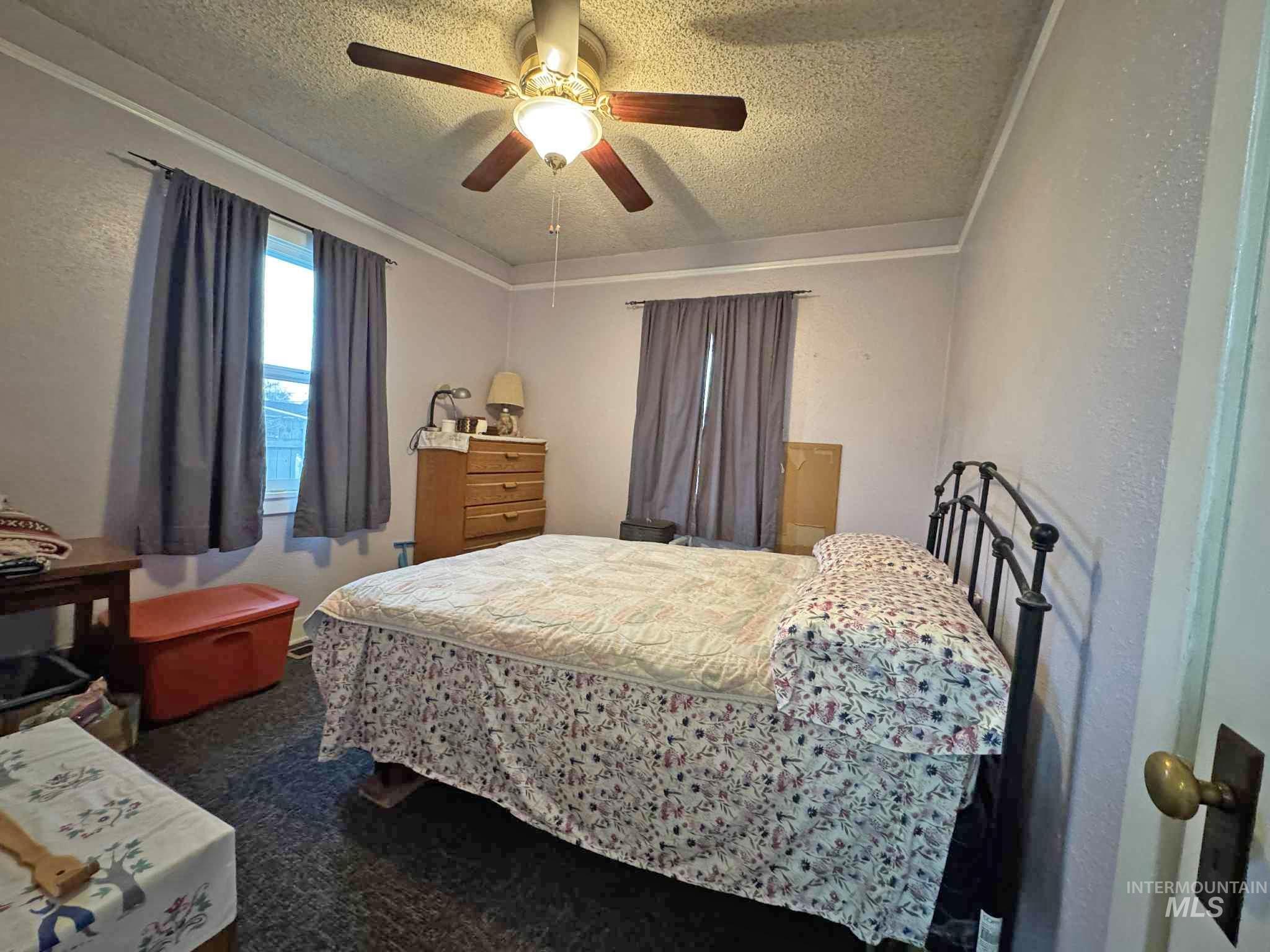 318 Maple Street Clarkston, WA 99403 - Photo 6 of 14 Bedroom featuring a textured ceiling, a ceiling fan, dark carpet, and a textured wall