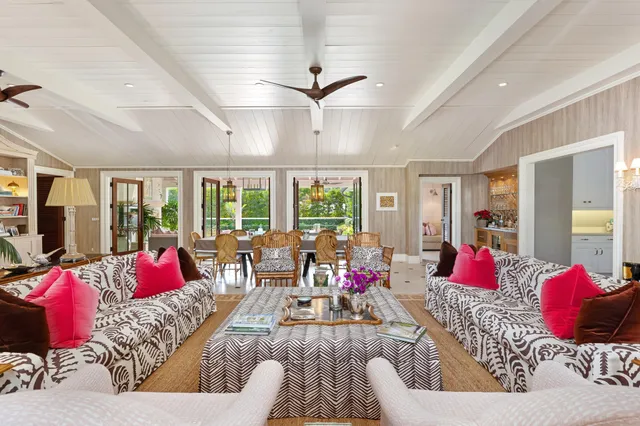 a living room with furniture kitchen view and large windows