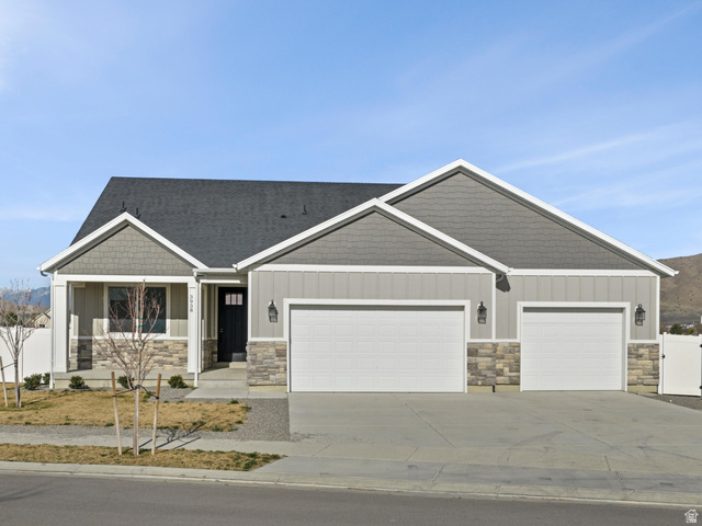 3938 North Wood Road Eagle Mountain, UT 84005 - Photo 3 of 55 Craftsman-style house featuring a gate, a mountain view, stone siding, a garage, and driveway