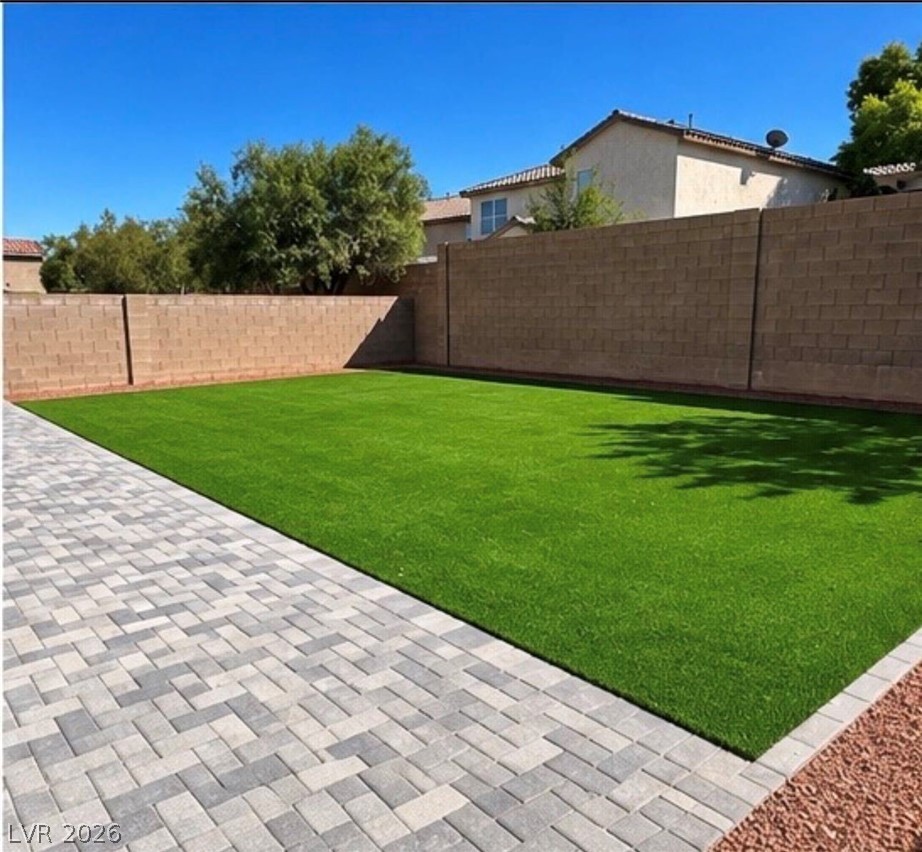 9639 West Post Road Las Vegas, NV 89148 - Photo 29 of 30 Manicured lawn and herringbone paver patio are enclosed by a privacy block wall.
