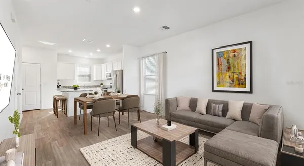 a living room with furniture kitchen view and a dining table