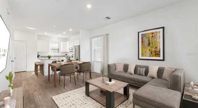 a living room with furniture kitchen view and a dining table