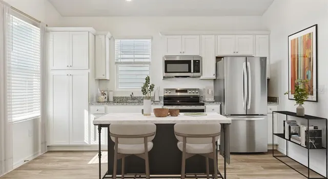 a kitchen with stainless steel appliances a refrigerator stove microwave and cabinets