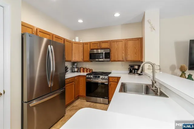 a kitchen with stainless steel appliances a refrigerator sink and microwave
