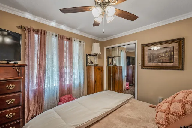 a bedroom with a large bed and a flat tv screen