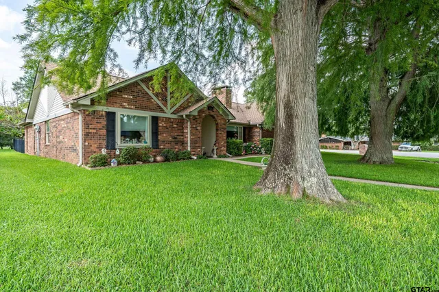 a front view of house with a garden and trees