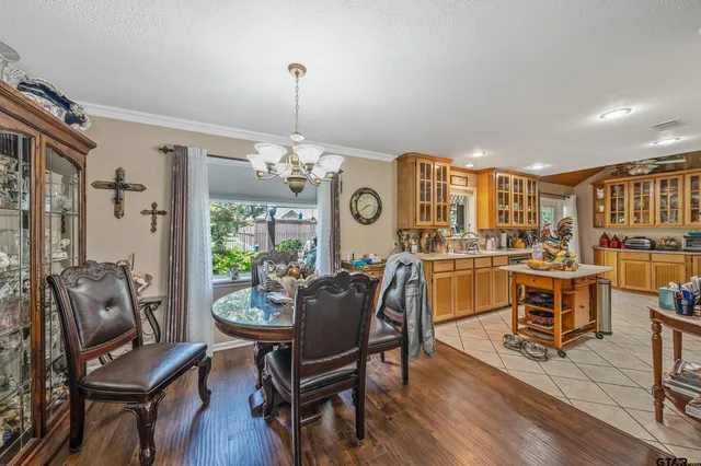 a dining room with furniture a chandelier and wooden floor