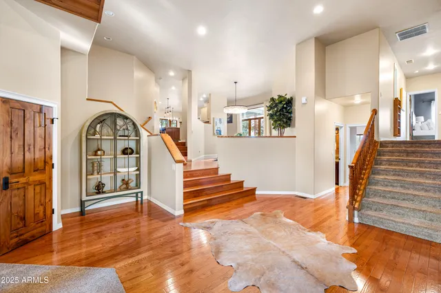 a view of a dining room with furniture a chandelier and wooden floor