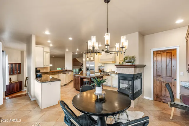 a view of a dining room with furniture large windows a chandelier and wooden floor