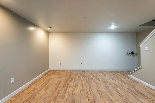an empty room with wooden floor and white walls