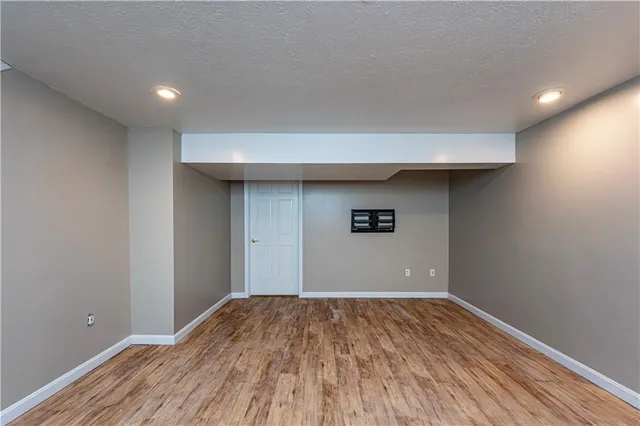 a view of a big room with wooden floor and a ceiling fan