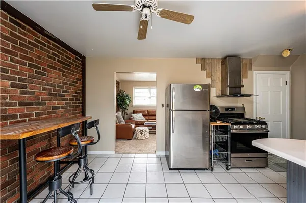 a kitchen with a refrigerator a stove and a dining table