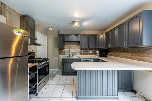 a kitchen with stainless steel appliances granite countertop a refrigerator a stove a sink and a microwave