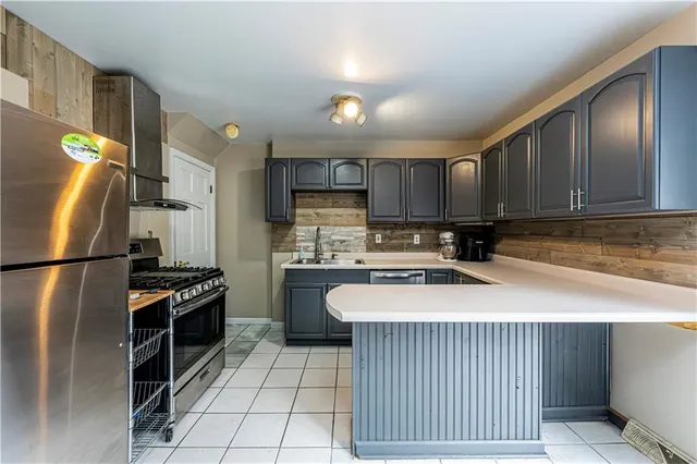 a kitchen with stainless steel appliances granite countertop a refrigerator a stove a sink and a microwave