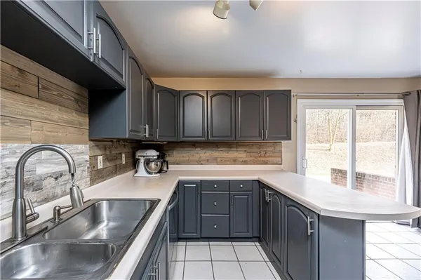 a kitchen with a sink cabinets a stove and a microwave oven