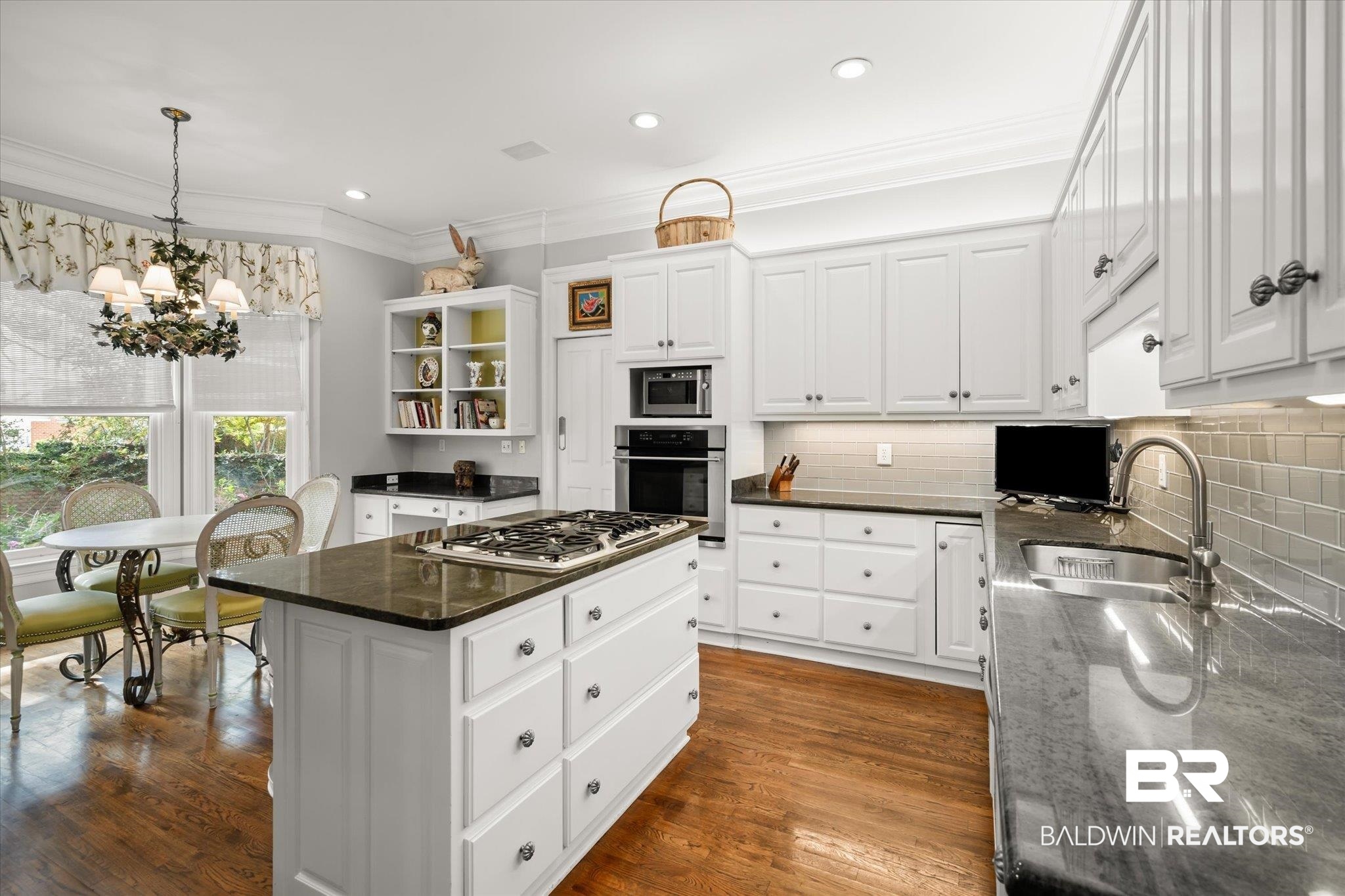 354 Dogwood Lane Mobile, AL 36608 - Photo 14 of 44 Kitchen with white cabinets, a chandelier, dark stone countertops, stainless steel appliances, and a center island