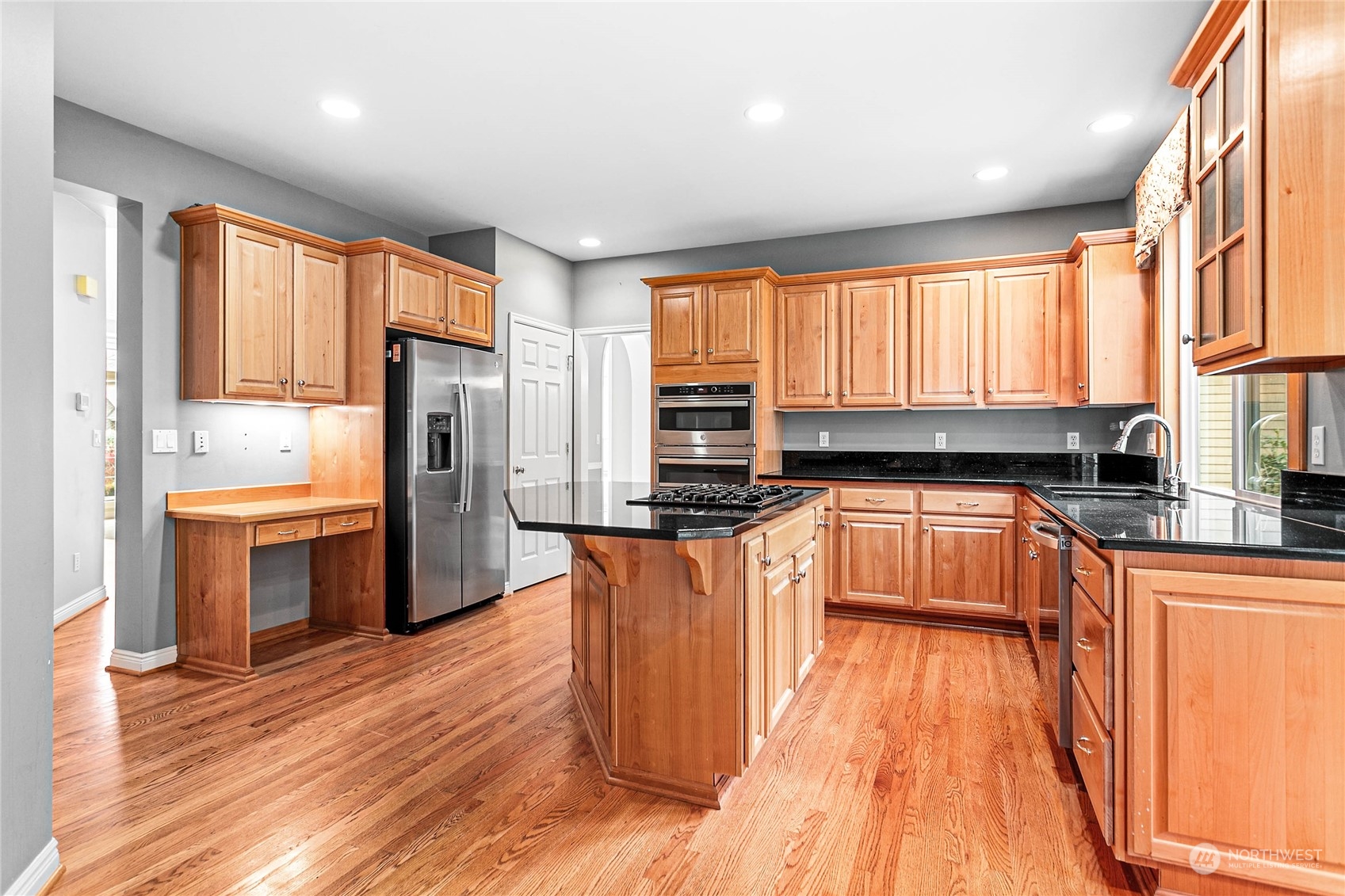 2509 201st Street Southeast Bothell, WA 98021 - Photo 7 of 33 a kitchen with stainless steel appliances granite countertop a refrigerator a sink dishwasher a stove and white countertops with wooden floor