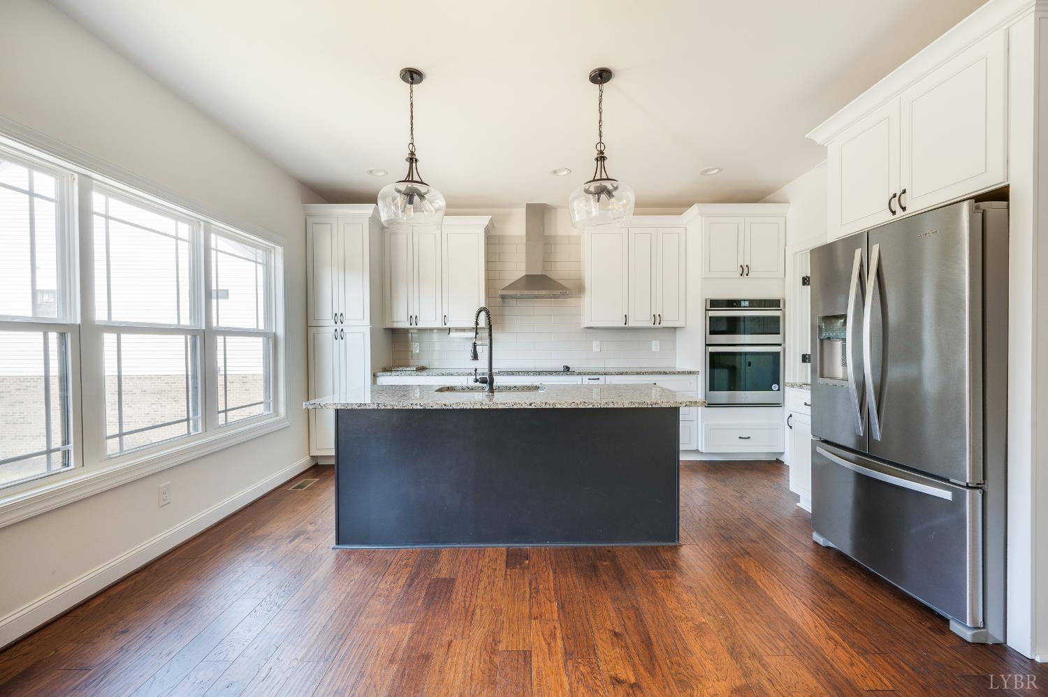 1089 Elk Creek Road Forest, VA 24551 - Photo 22 of 67 a kitchen with stainless steel appliances granite countertop a refrigerator a sink dishwasher a stove and white countertops with wooden floor