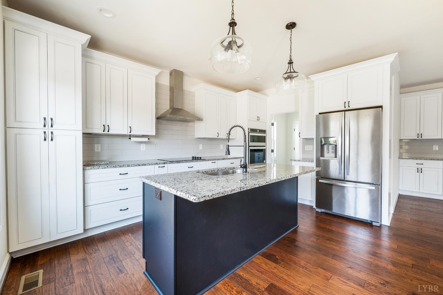 1089 Elk Creek Road Forest, VA 24551 - Photo 23 of 67 a kitchen with stainless steel appliances granite countertop a refrigerator a sink dishwasher a stove and white countertops with wooden floor