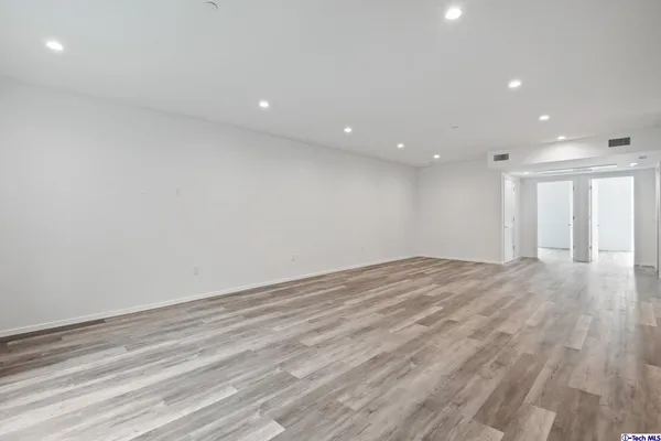 a view of an empty room with wooden floor