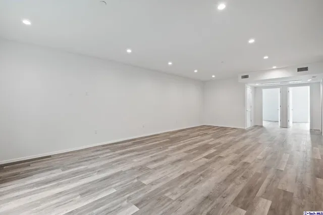 a view of an empty room with wooden floor