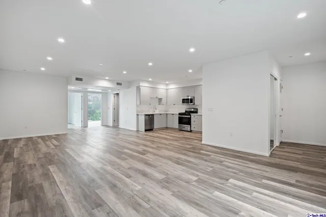 a kitchen with cabinets stainless steel appliances and wooden floor