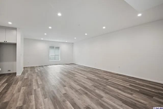 a large kitchen with stainless steel appliances a large counter top a sink and a refrigerator