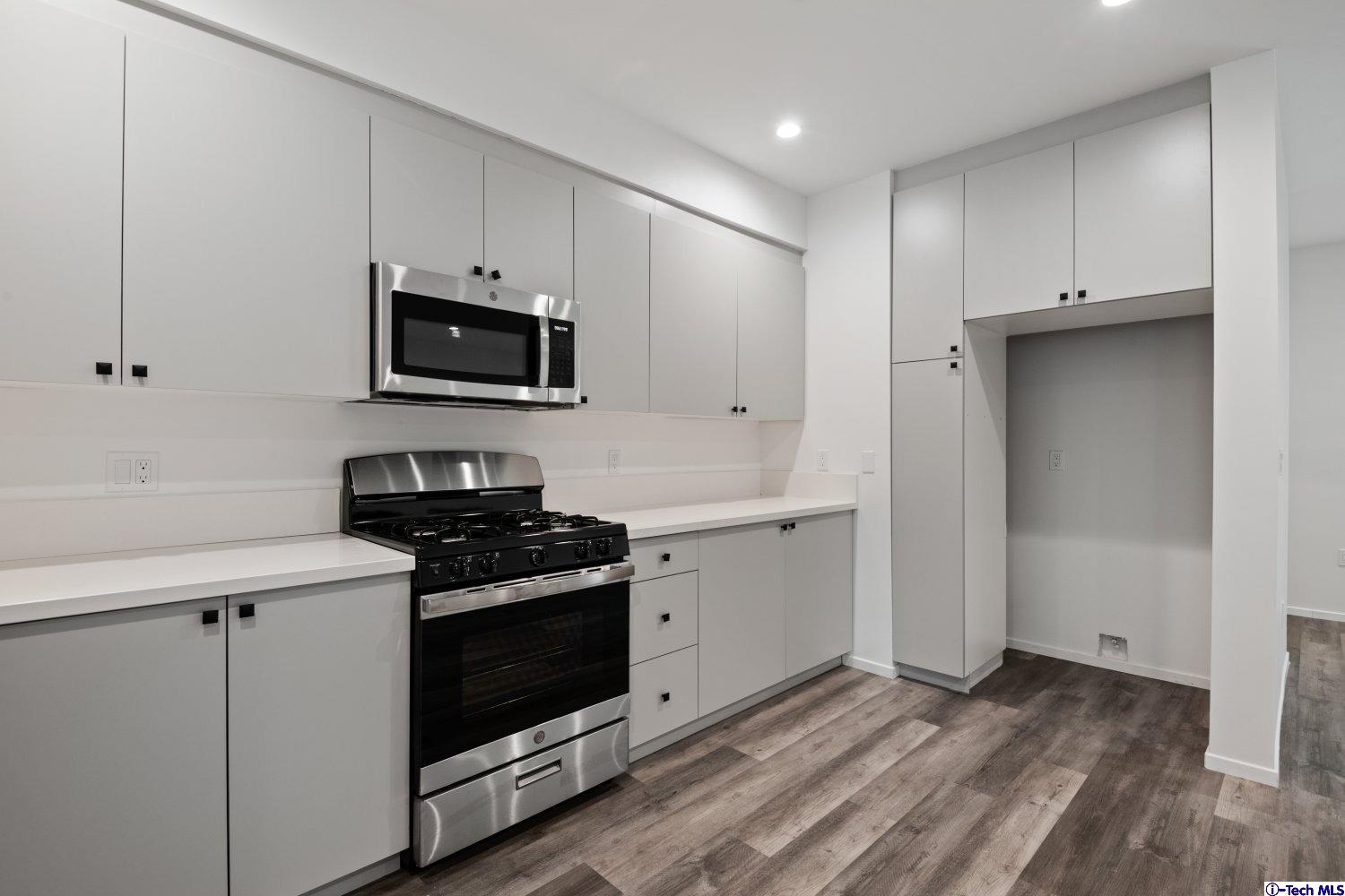 7064 Greeley Street, Unit 204 Tujunga, CA 91042 - Photo 20 of 39 a kitchen with cabinets stainless steel appliances and wooden floor