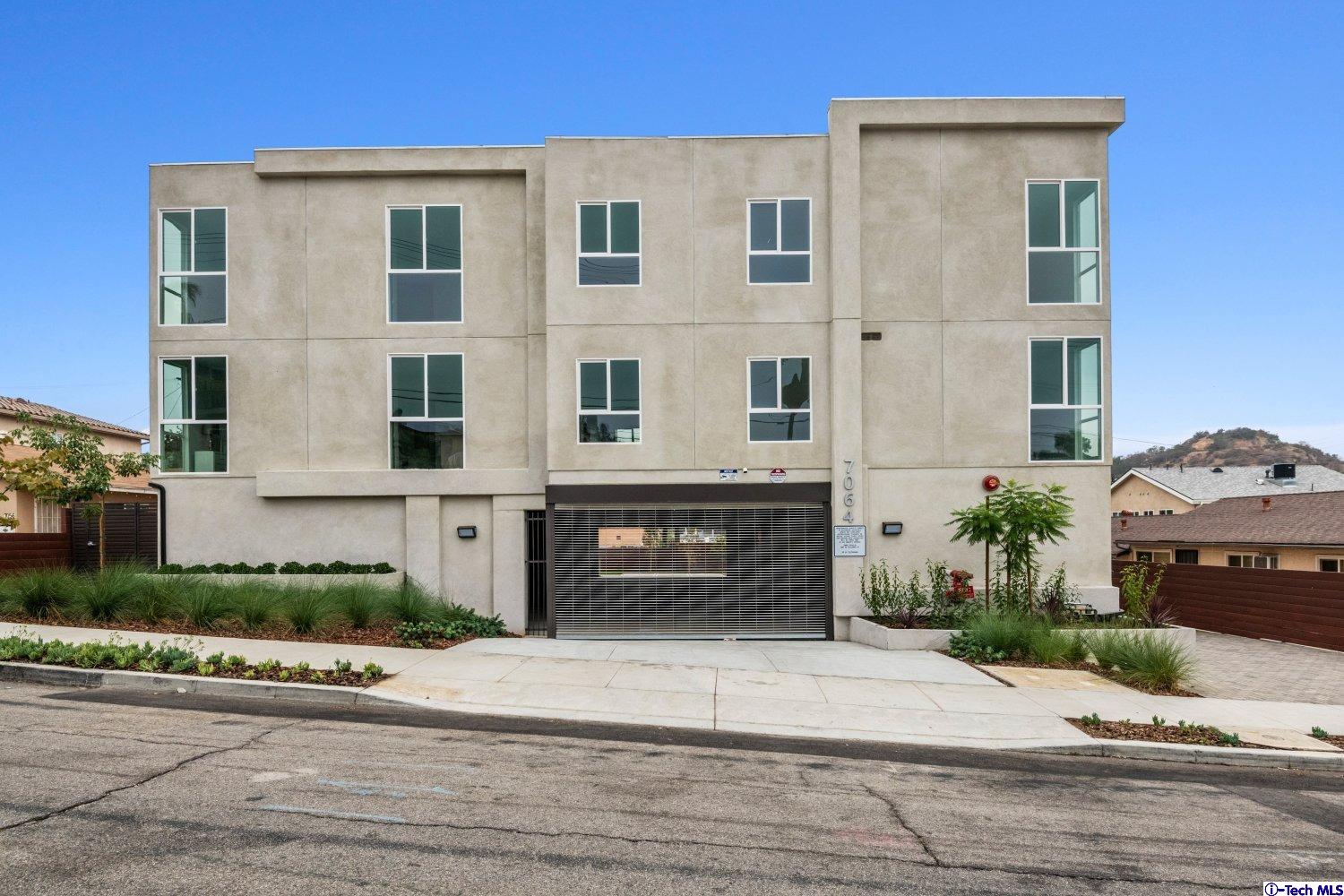 7064 Greeley Street, Unit 204 Tujunga, CA 91042 - Photo 3 of 39 a front view of a house with a yard and garage