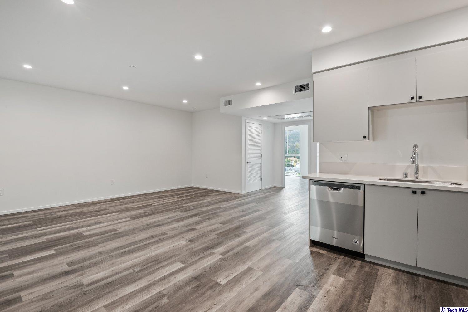 7064 Greeley Street, Unit 204 Tujunga, CA 91042 - Photo 22 of 39 a large kitchen with stainless steel appliances a large counter top a sink and a refrigerator