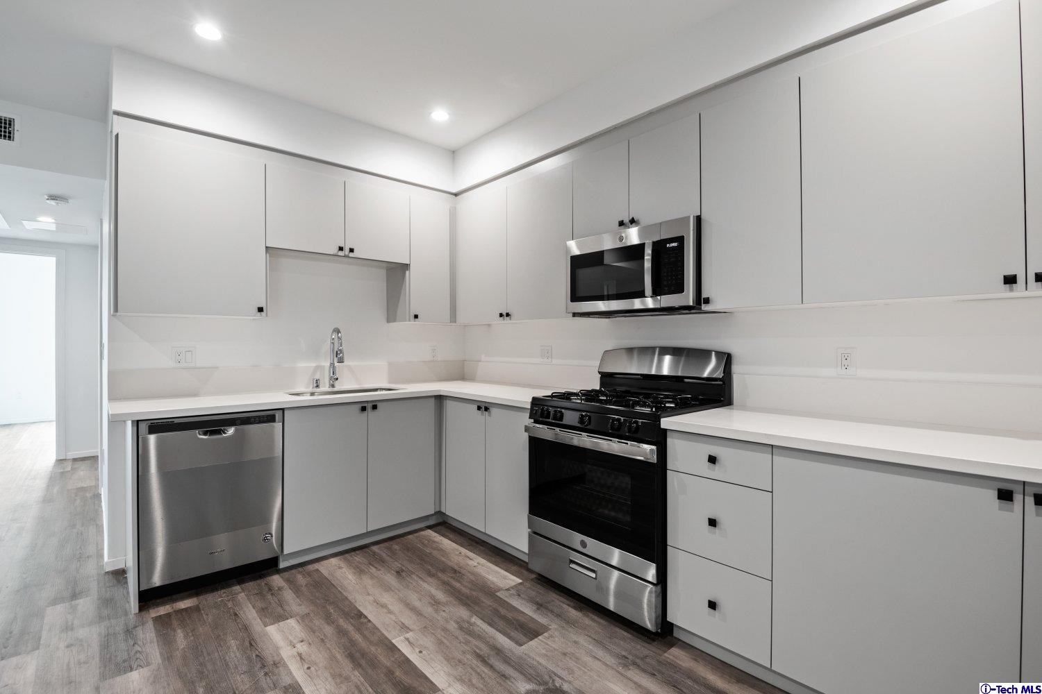 7064 Greeley Street, Unit 204 Tujunga, CA 91042 - Photo 23 of 39 a kitchen with a sink stove and cabinets