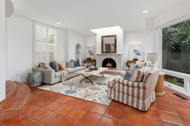 a living room with couches a dining table and a potted plant