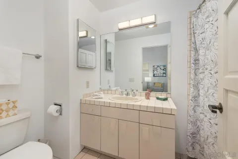 a view of a room with a large mirror and a chandelier fan