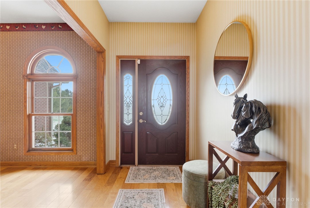 1540 Jasper Road Xenia, OH 45385 - Photo 12 of 91 The inviting entryway features gleaming hardwood floors and natural light from arched windows and a decorative glass door.
