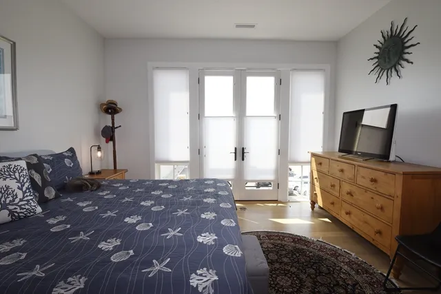 a bedroom with a large bed and flat tv screen on dresser