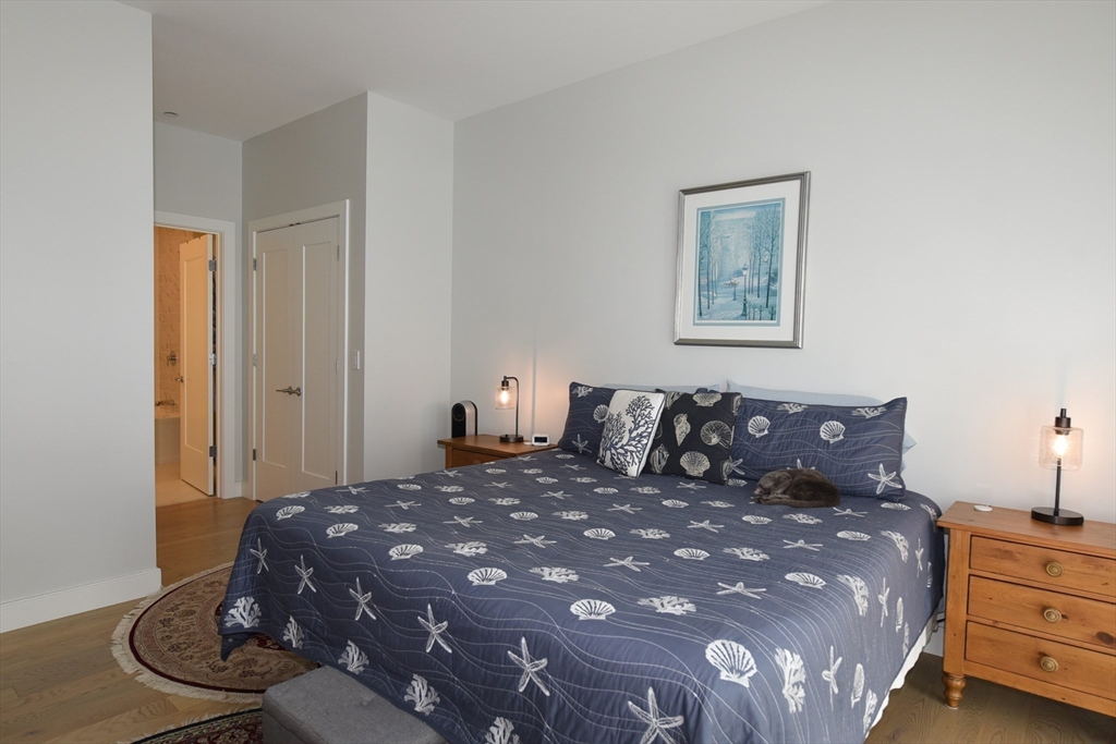 10 Shipyard Drive, Unit 313 Hingham, MA 02043 - Photo 15 of 39 a large bed sitting in a bedroom next to a window and a lamp