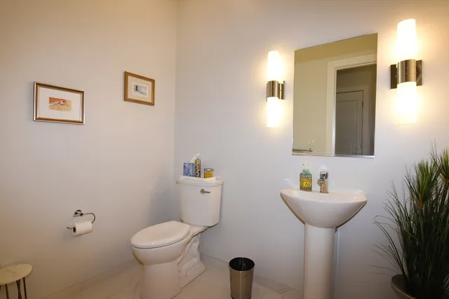 a bathroom with a toilet sink and mirror