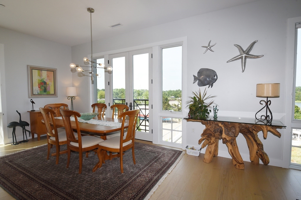 10 Shipyard Drive, Unit 313 Hingham, MA 02043 - Photo 4 of 39 a dining room with furniture a chandelier and wooden floor